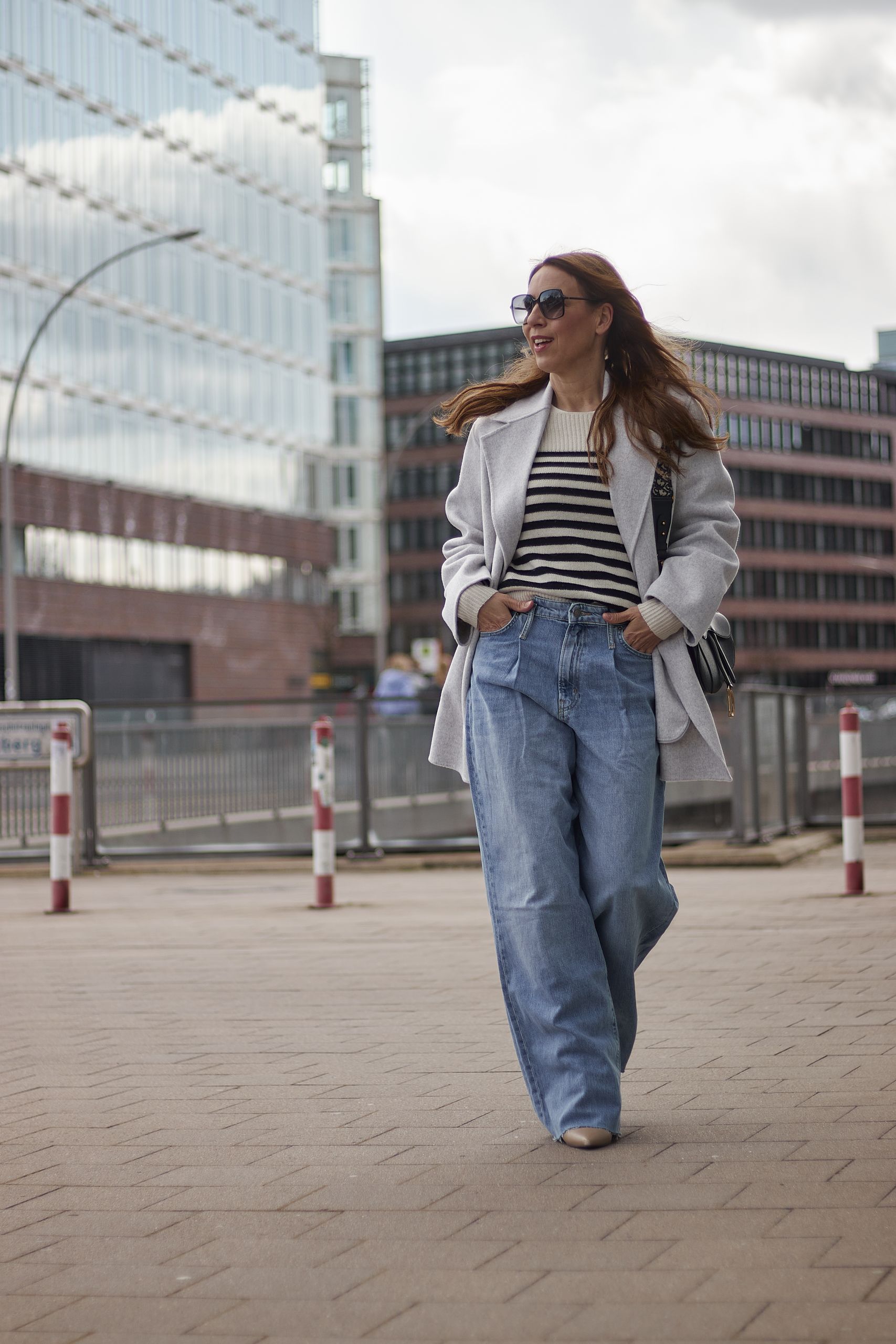 Streifenpullover zur Jeans Schlaghose kombinieren in der Hafencity von Hamburg