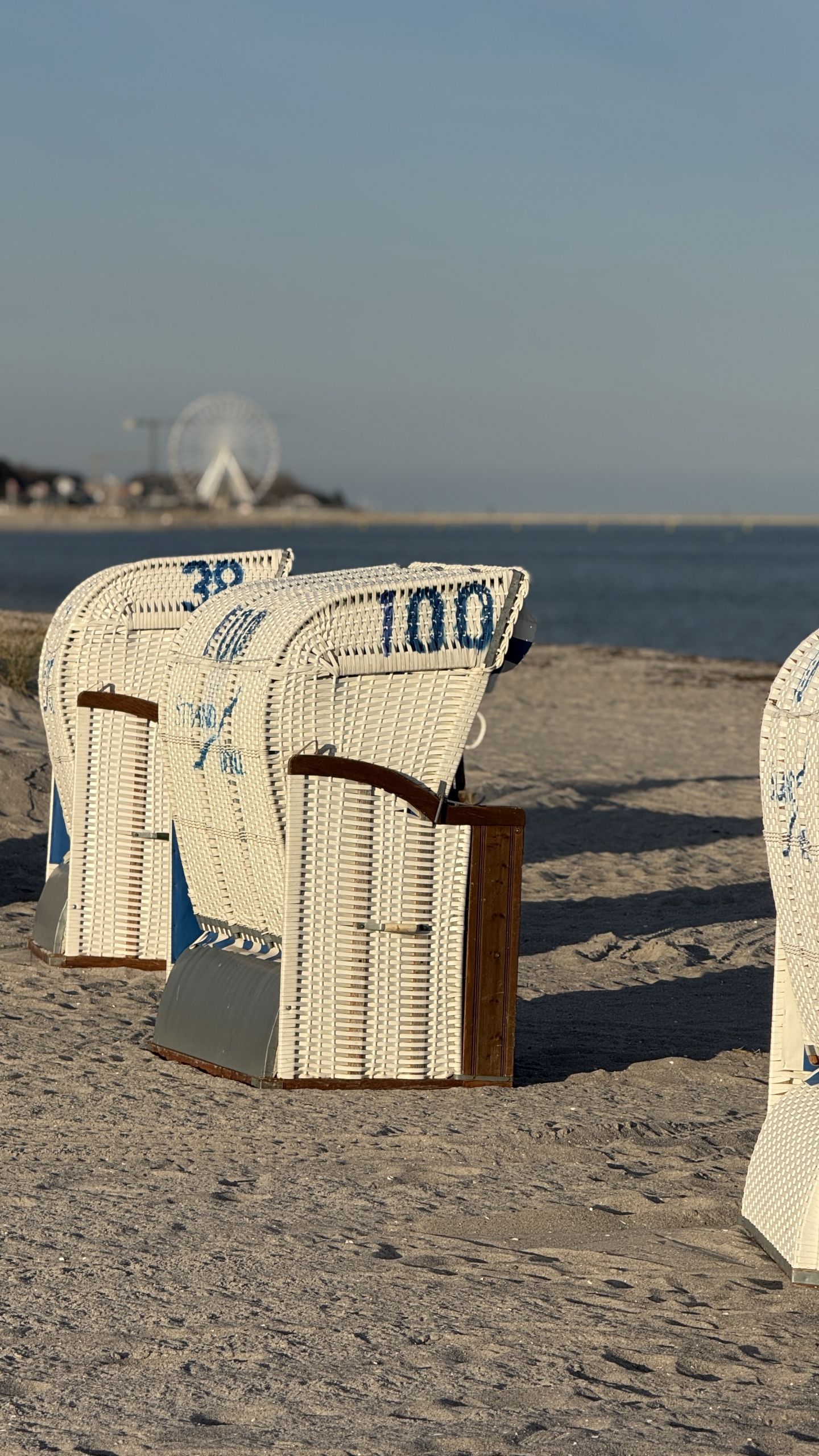 Strandkörbe in Grömitz mit Blick aufs Wasser sowie das Riesenrad